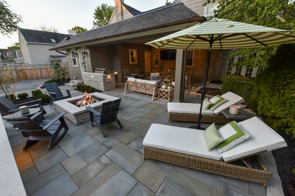 Peabody residential outdoor room with layered patio, fire feature, covered porch, and compact planting edges